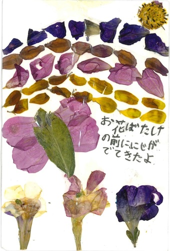 写真：子供の部入選の伊藤凛子（いとうりんこ）さん（横手市在住）の押し花は「お花ばたけの前ににじがでてきたよ」という言葉が添えられた花畑と蝶のバックに虹を描いた作品。