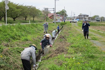 水路の泥上げを行う人々