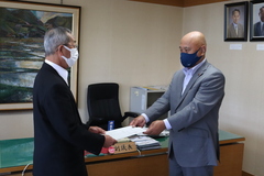 写真：播磨議長に報告書を手渡す菅原委員長