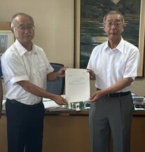 写真：小野議長に報告書を手渡す播磨委員長