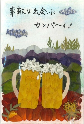 写真：大人の部特選の佐藤政子さん（横手市在住）の押し花は「素敵な出会いにカンパ―イ！」という言葉が添えられた野山とビールジョッキがモチーフとなった作品。
