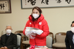 写真：母校の児童生徒が作った応援幕を受け取る向川さん